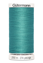 Teal spool of Gütermann thread on a white background