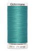 Teal spool of Gütermann thread on a white background