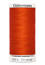 Spool of orange thread with 'Gütermann' branding on a white background