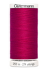 Spool of Gutermann thread in bright pink on a white background