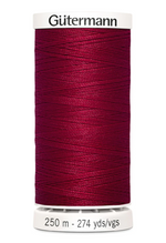 Spool of red thread with 'Gütermann' branding on a white background
