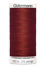 Spool of red thread with 'Gütermann' branding on a white background