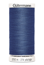 Spool of blue Gutermann thread on a white background