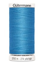 Blue spool of Gutermann thread on a white background
