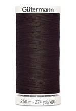 Spool of black Gutermann thread on a white background