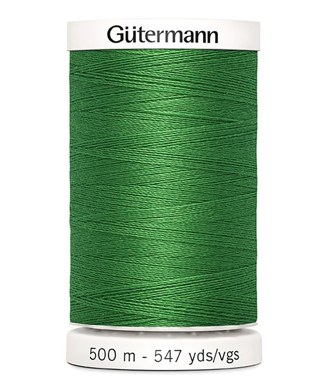 Green spool of Gutermann thread on a white background
