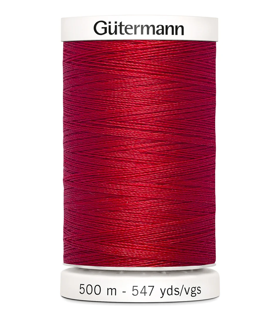 Spool of red Gutermann thread on a white background