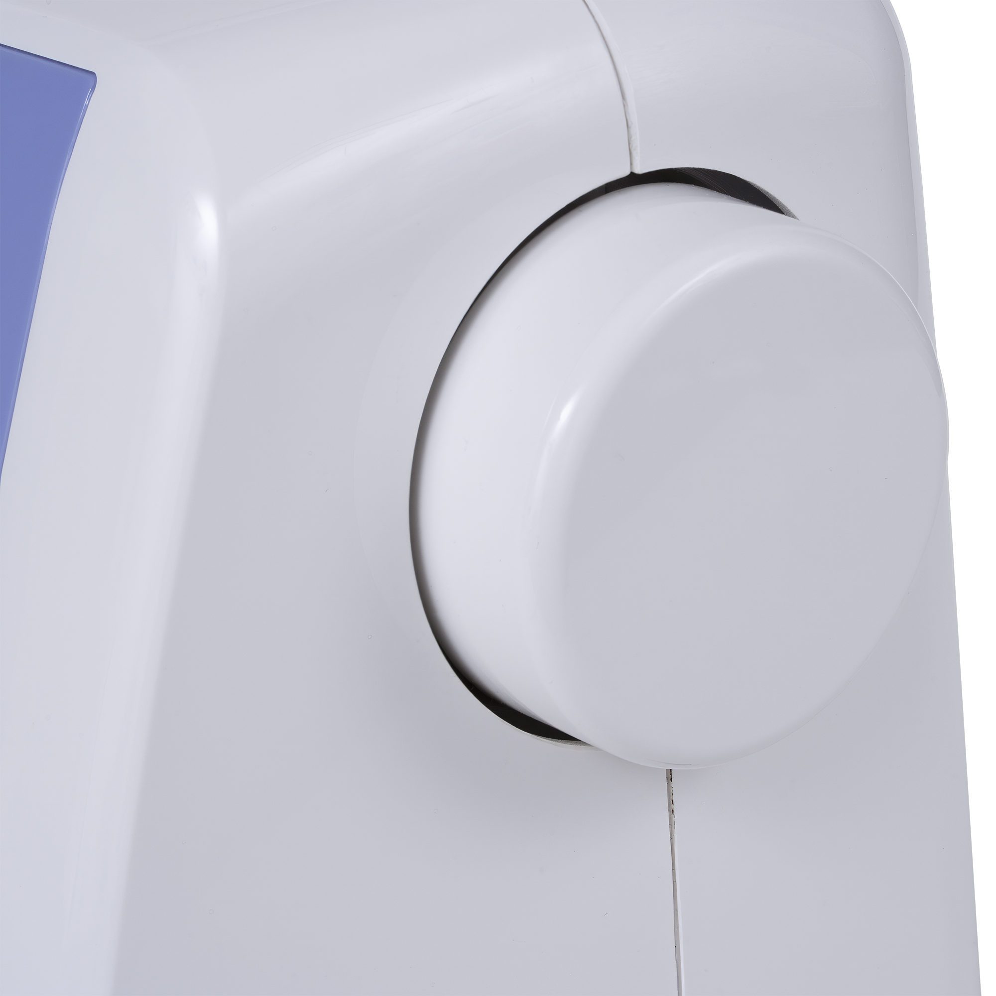 Close-up of a white circular control dial on a white sewing machine, with a small blue panel visible at the upper left edge.