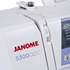 Close-up of a Janome 5300QDC sewing machine showing the white body, red and blue brand text, dial settings, and part of the control panel.