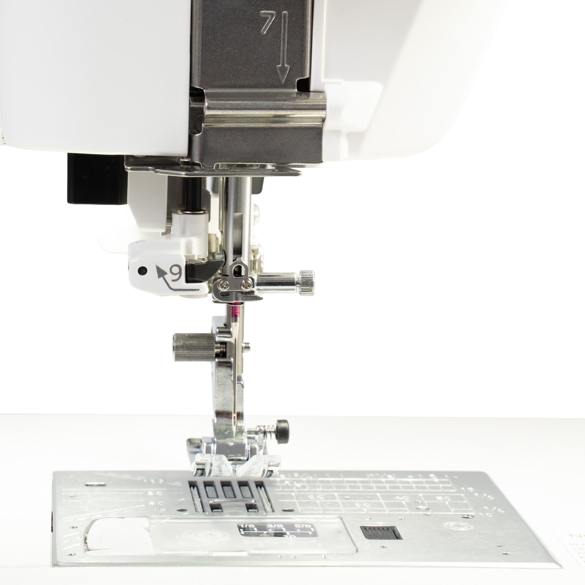 Close-up of a sewing machine presser area and metal needle plate on a white background.
