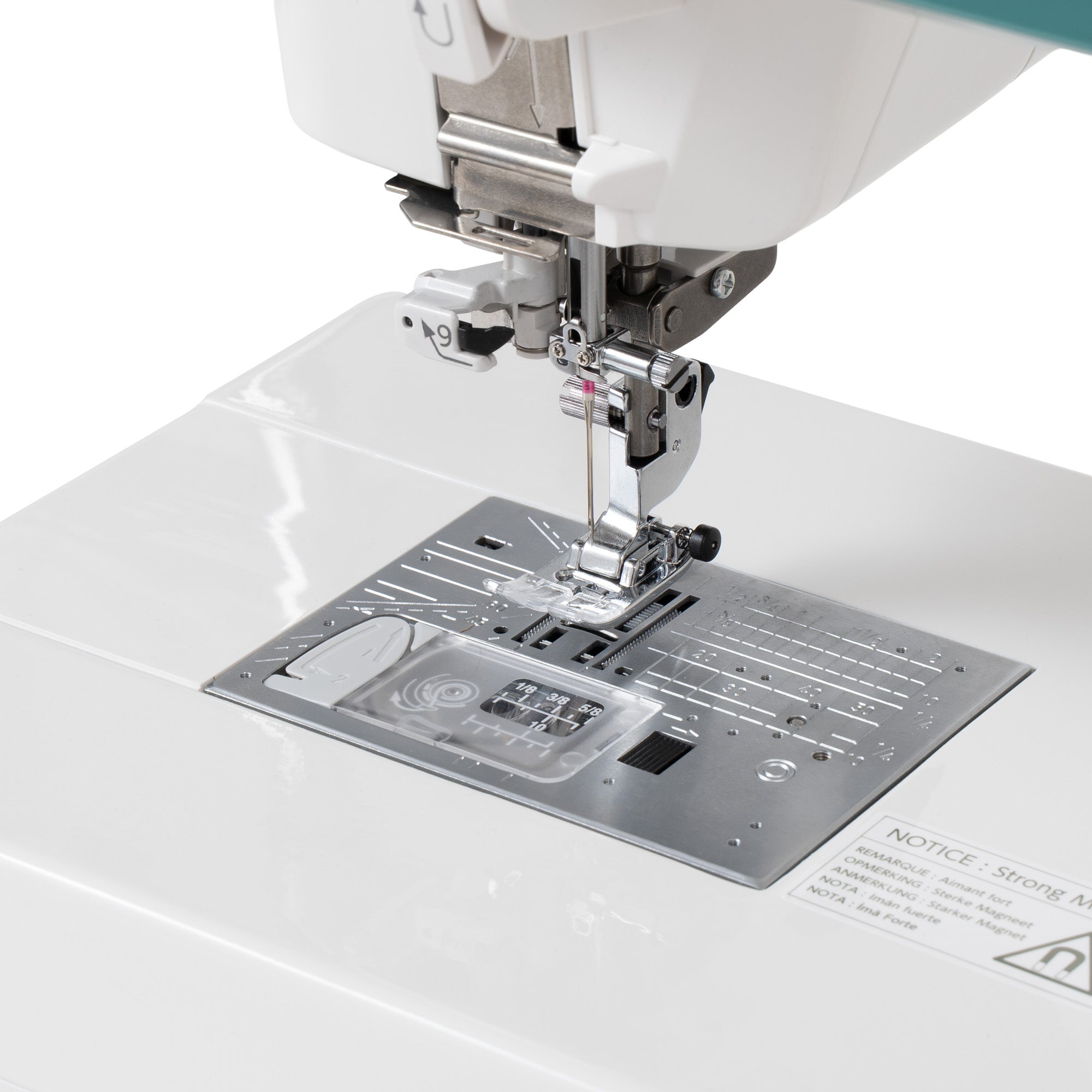 Close-up of a white sewing machine showing the presser foot, needle, fabric feed area, and metal plate on a clean white background.
