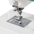 Close-up of a white sewing machine showing the presser foot, needle, fabric feed area, and metal plate on a clean white background.