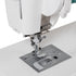 Close-up of a white sewing machine with a metallic presser foot and silver metal plate on a clean white background.