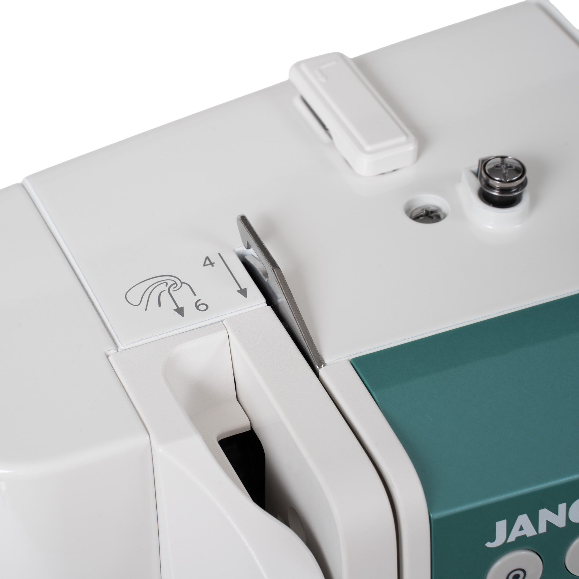 Close-up of a white and teal Janome sewing machine showing the thread selector dial with arrows and numbers 4 and 6.