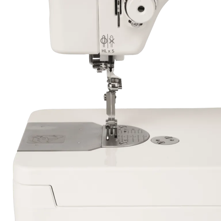 Close-up of a white sewing machine showing the needle area, presser foot, metal plate, and a small round metal dial on the side, photographed on a clean white background.