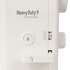 Close-up of a white sewing machine panel with the text 'Heavy Duty 9 PROFESSIONAL' and a circular button with a scissors icon.