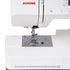 Close-up of a white Janome sewing machine showing the needle area, press foot, fabric guide, and part of the control panel on a clean white background.