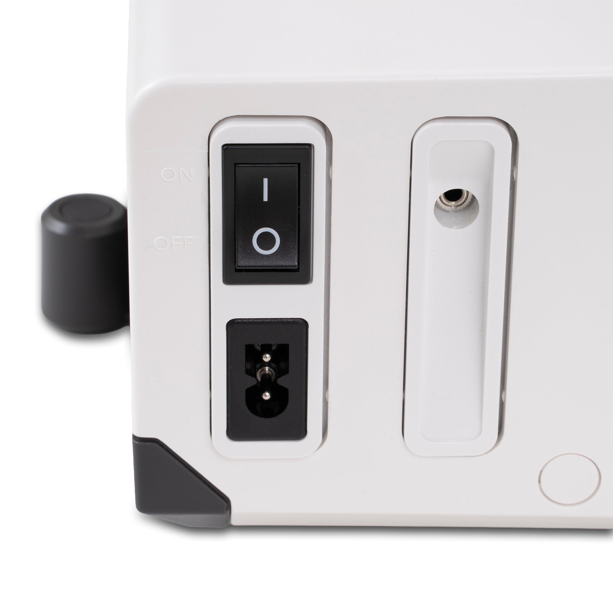 Close-up of the rear or side control panel of a white electronic device, showing a black rocker switch, a power inlet, a small circular port, and a black knob on a white background.