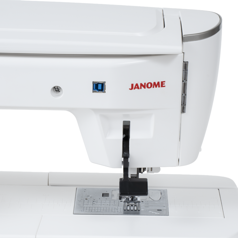 Close-up of a white Janome sewing machine showing the side panel, red Janome logo, black presser foot, and metal needle plate on a clean white background.