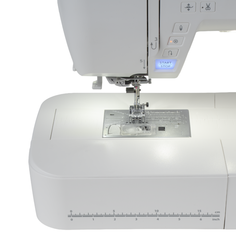 Close-up of a white sewing machine showing the needle area, press foot, stitch selector, and a small blue START/STOP display on a clean white background.