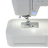 Close-up of a white sewing machine showing the needle area, press foot, stitch selector, and a small blue START/STOP display on a clean white background.