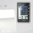 Close-up of a white sewing machine featuring a large, angled digital touch control screen displaying a dark blue and gray user interface.