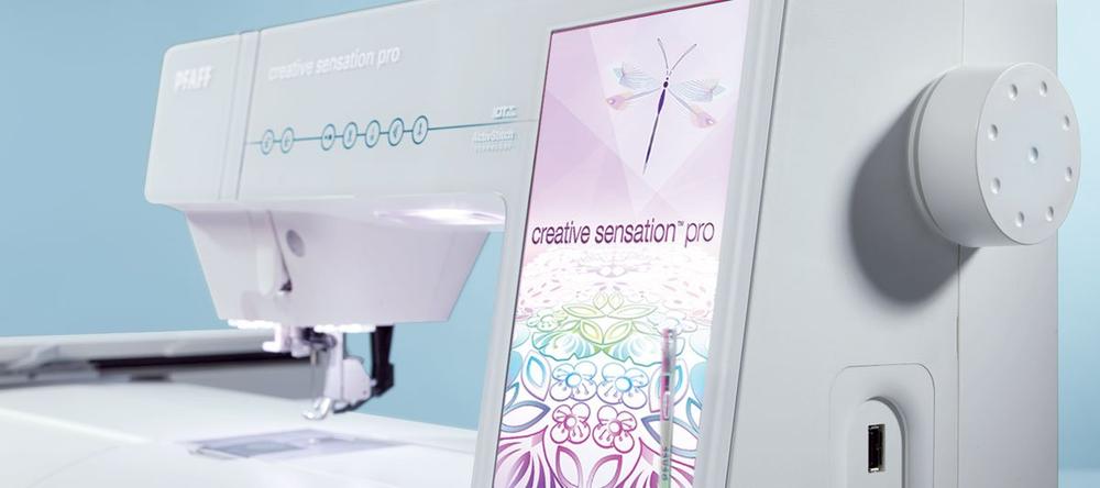 Sewing machine with a digital display showing embroidery designs on a light blue background
