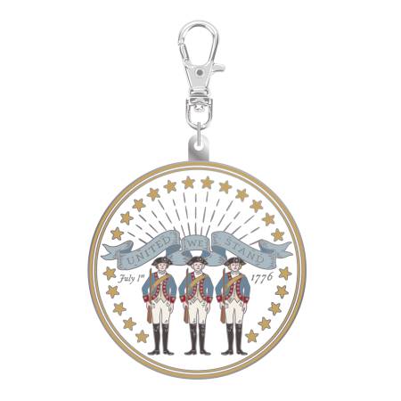 Circular keychain with three figures and a banner on a white background