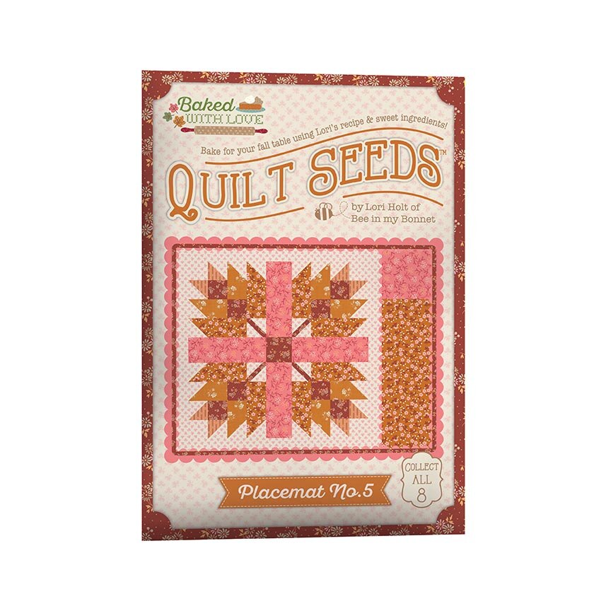 Baked with Love Quilt Seeds Placemat No. 5 kit packaging, featuring a quilt pattern illustration in pink, orange, and brown on a cream background with a red patterned border.
