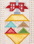 A close-up of a quilted fabric ornament design with a red bow at the top, a yellow diamond shape, and smaller geometric sections in blue, green, and brown on a cream patterned fabric background.