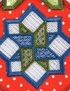 Close-up of a colorful embroidered geometric patch featuring a blue and green star-like pattern over white mesh sections on a red polka-dot fabric background.