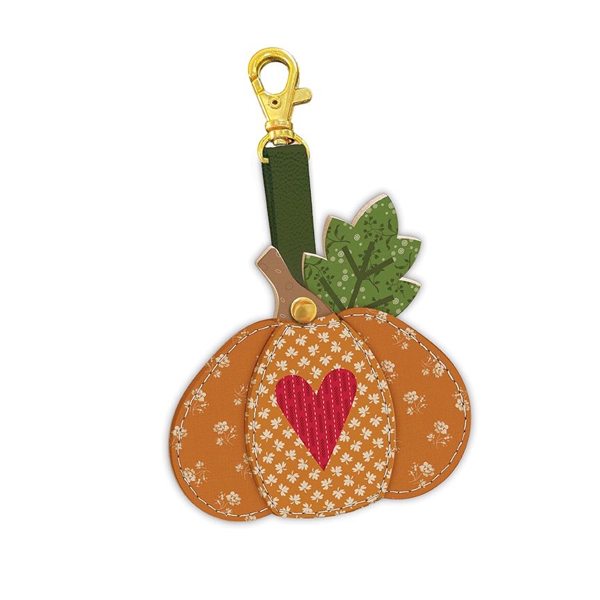 Pumpkin-shaped keychain with a heart design on a white background