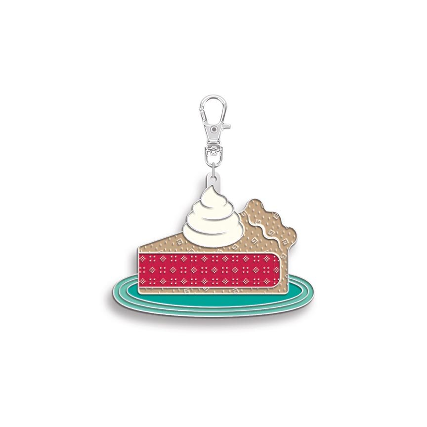 Keychain shaped like a slice of pie with whipped cream on a white background