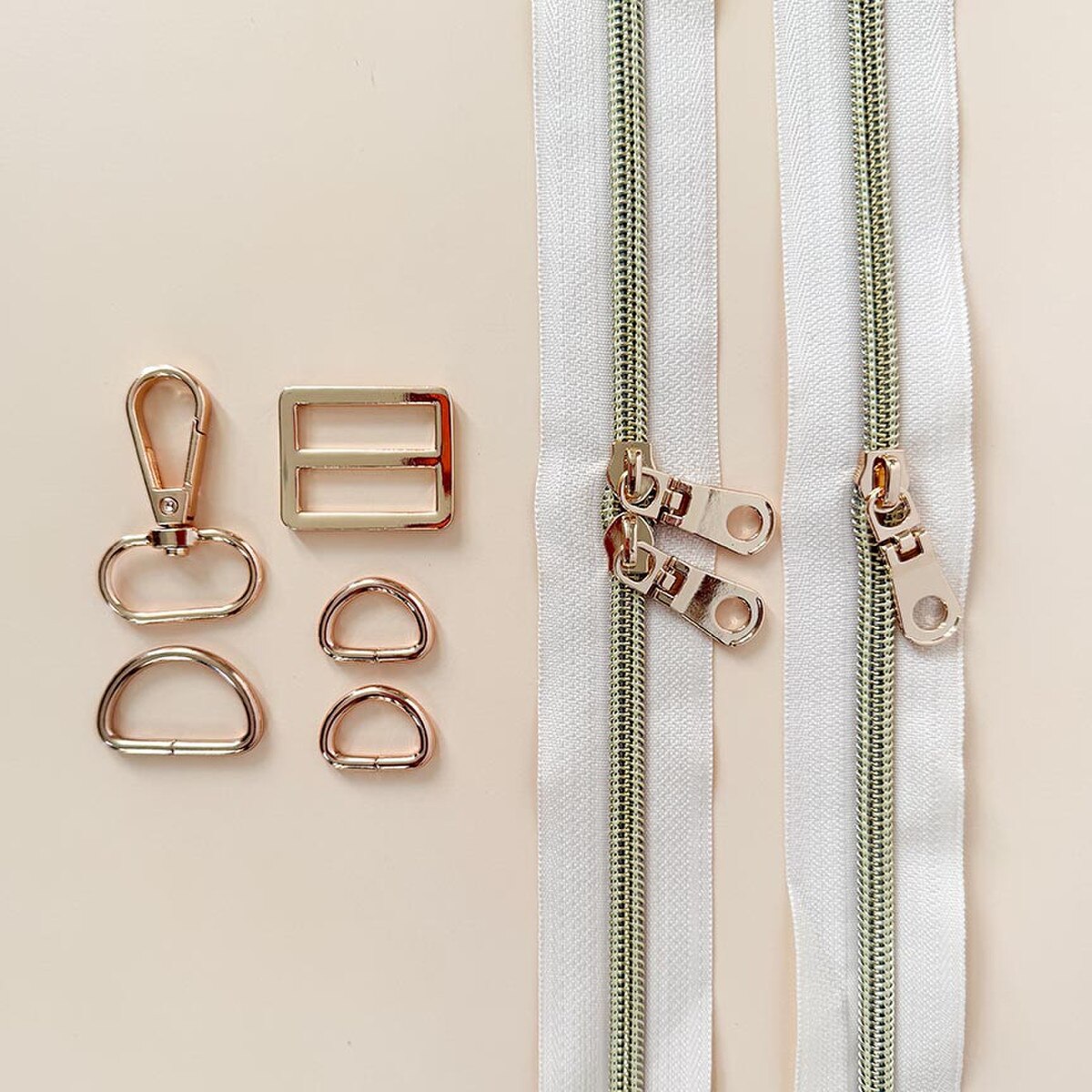 Gold zippers and hardware on a beige background