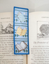 Decorative bookmark with illustrations of books on an open book
