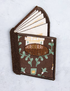 Brown fabric cardholder with green pattern on a light gray background