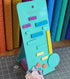 Turquoise sewing tool with colorful components on a cutting mat with fabric in the background