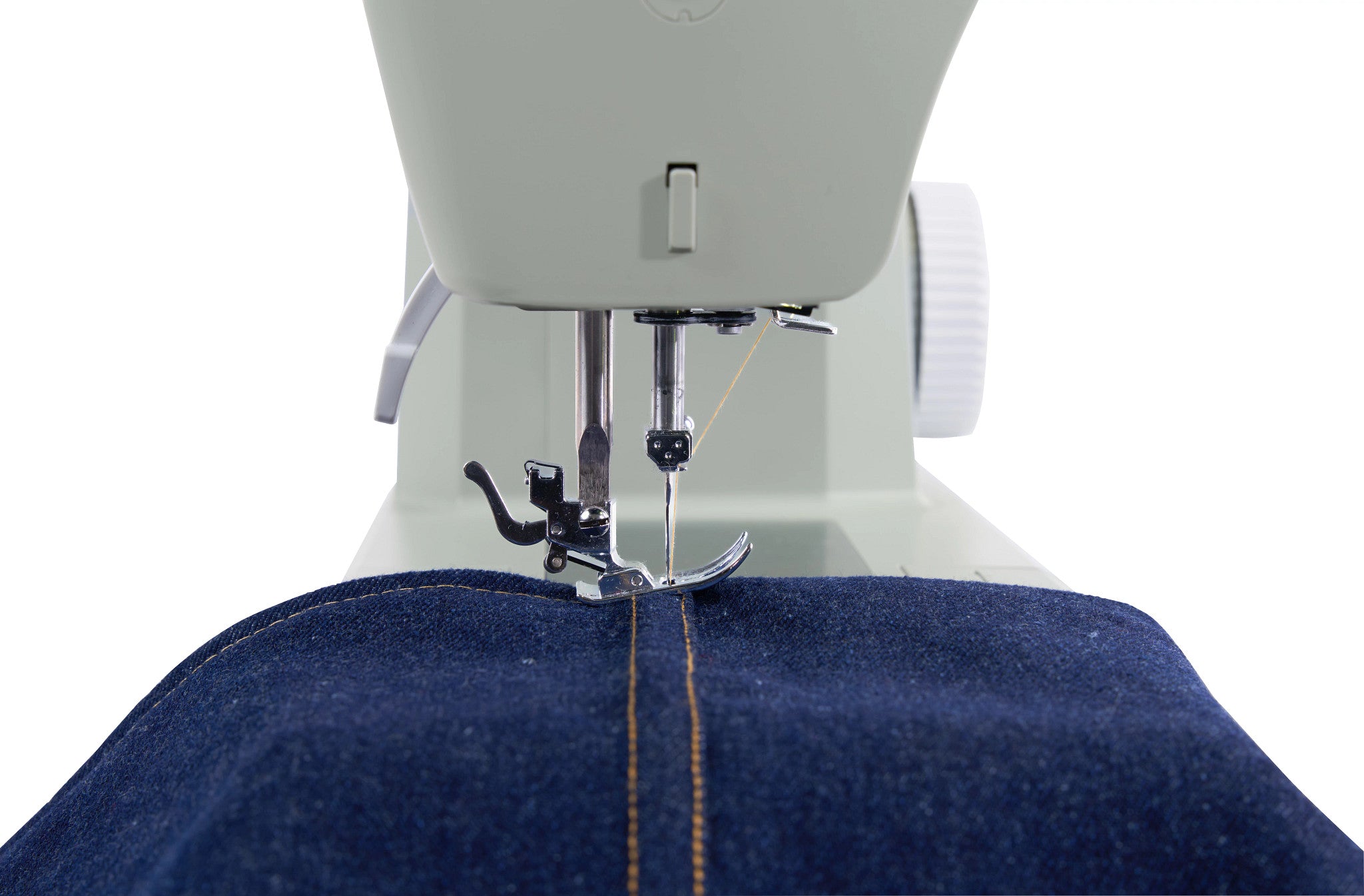 Close-up of a sewing machine stitching dark blue denim fabric with a visible orange-yellow contrast stitch on a white background.
