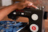 A close-up of a person's hand operating a black Singer Heavy Duty sewing machine, stitching blue patterned fabric.