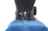 Close-up of a black sewing machine needle and presser foot stitching blue denim fabric against a white background.