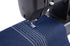 Close-up of a black sewing machine stitching dark blue denim fabric with white zigzag and straight stitch details on a white background.