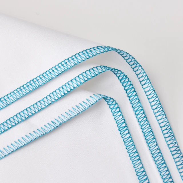 A close-up of a white ribbon with a bright turquoise blue zigzag patterned border, draped elegantly on a clean white background.