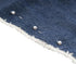 Close-up of blue denim fabric with white stitching and pins on a white background