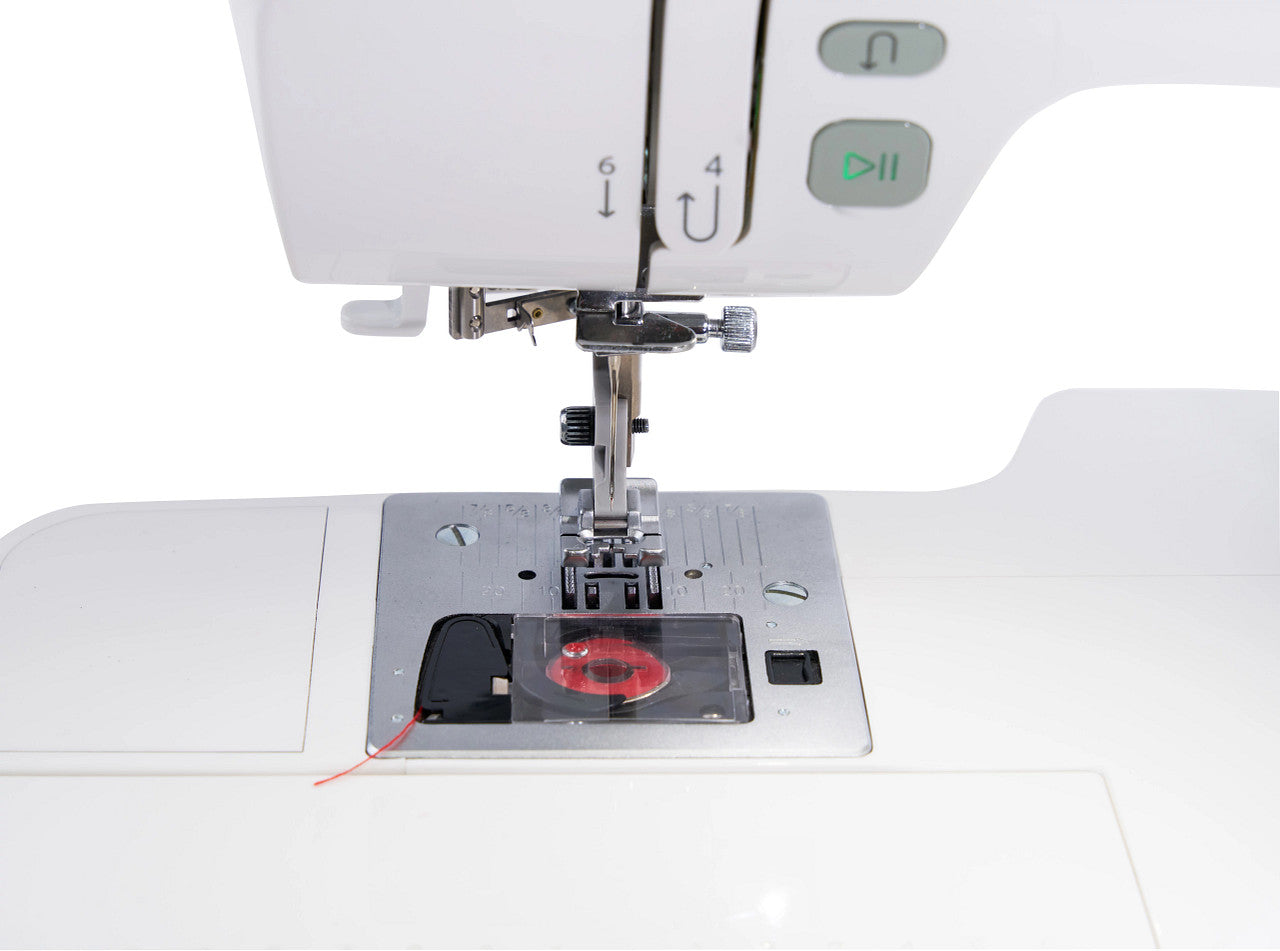 Close-up of a white sewing machine showing the needle area, press foot, metal plate, thread spool, and control buttons on a white background.