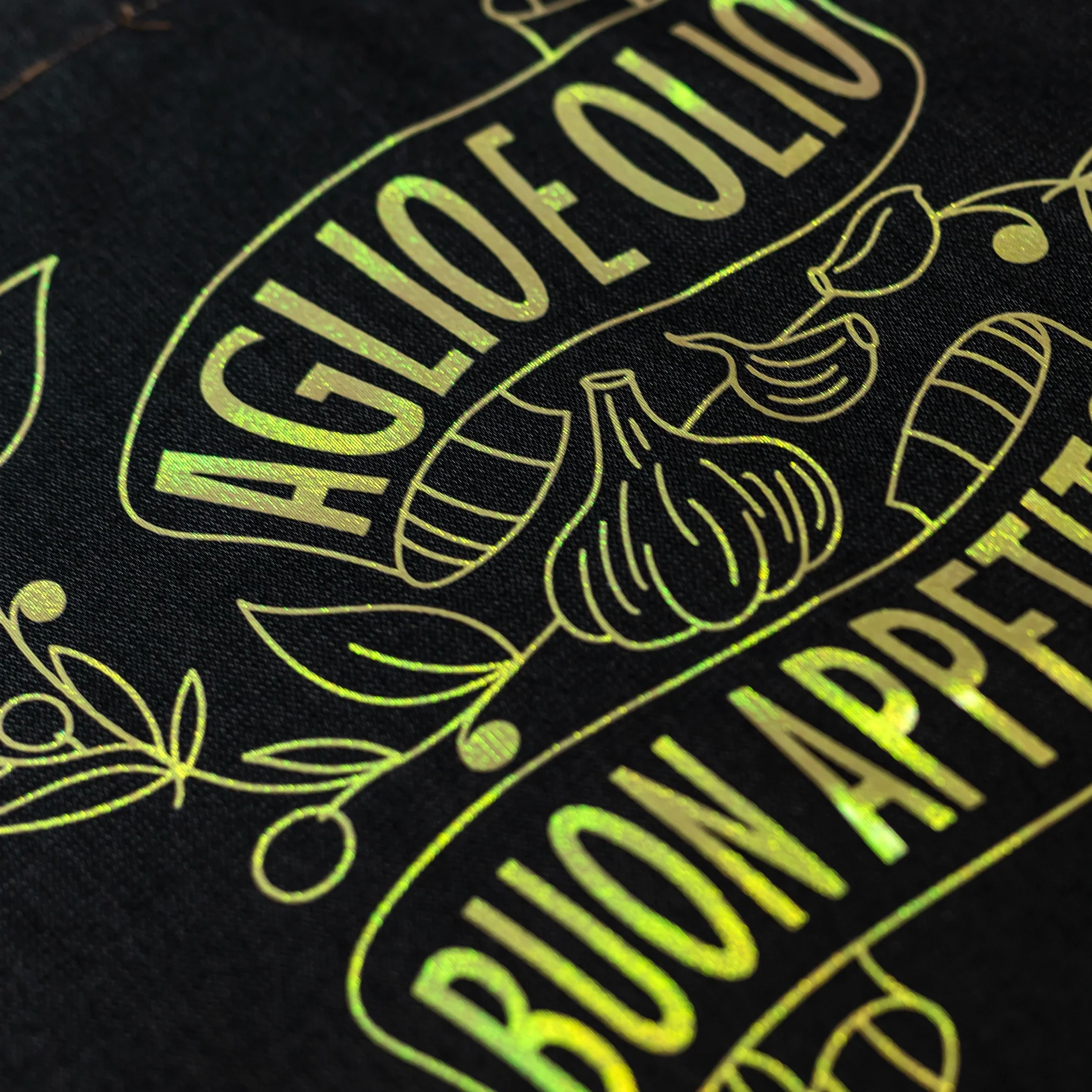 Holographic foil design with garlic and olive oil text on a black background