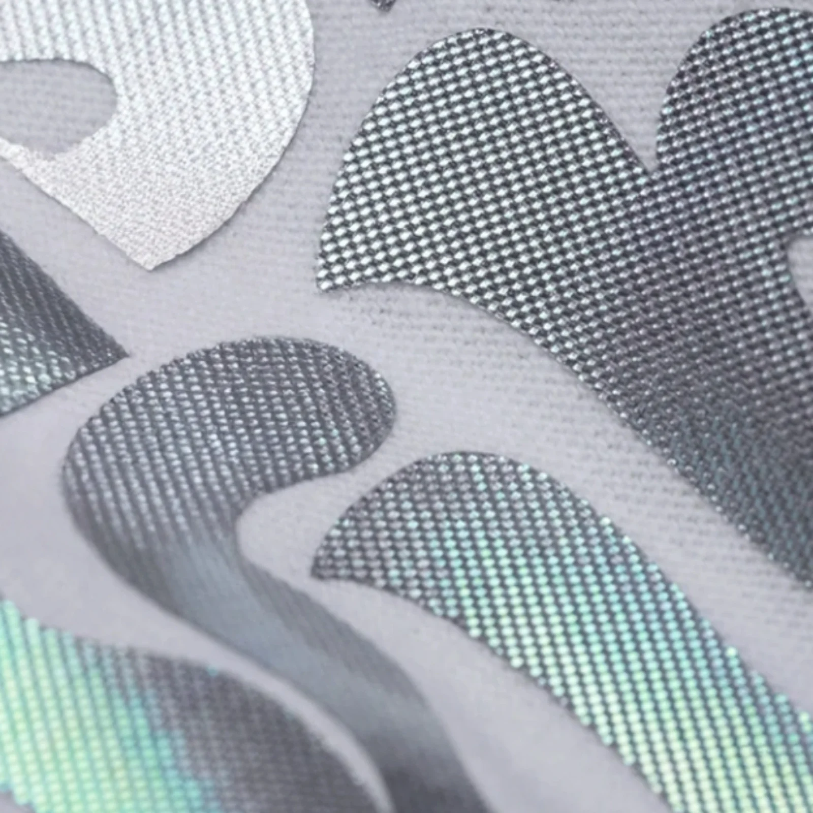 Close-up of textured vinyl with geometric patterns in gray, black, and green.