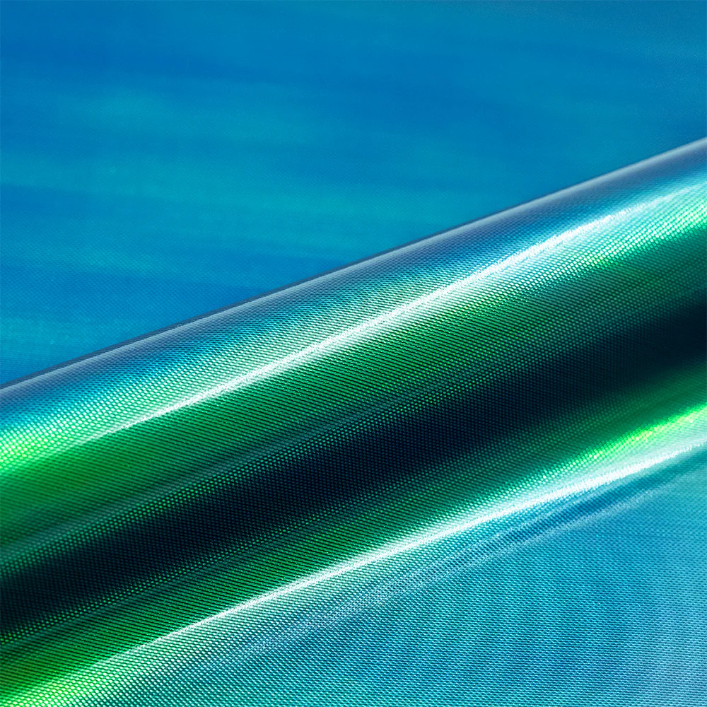 Close-up of green and blue gradient vinyl roll with texture against a blue background