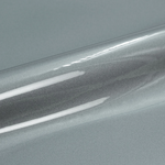 Close-up of a roll of silver reflective vinyl wrap on a gray background
