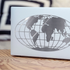 White box with a black globe design on a wooden surface