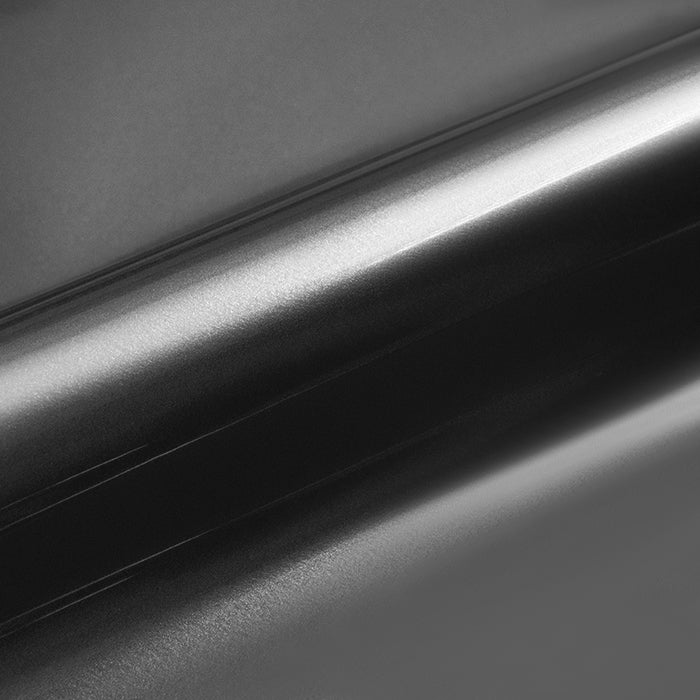 Close-up of a roll of black vinyl wrap on a dark background